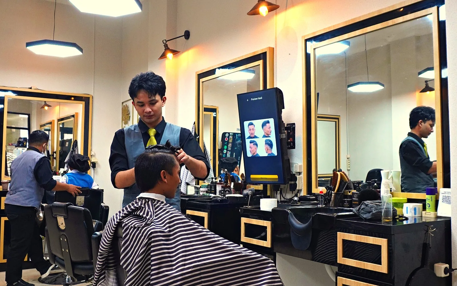 Layar Hair Guide terpasang di samping kursi cukur