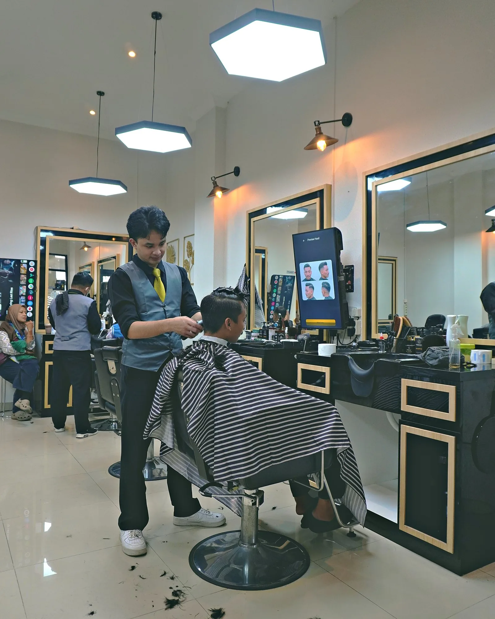 Capster menyisir rambut pelanggan sebelum ditata
