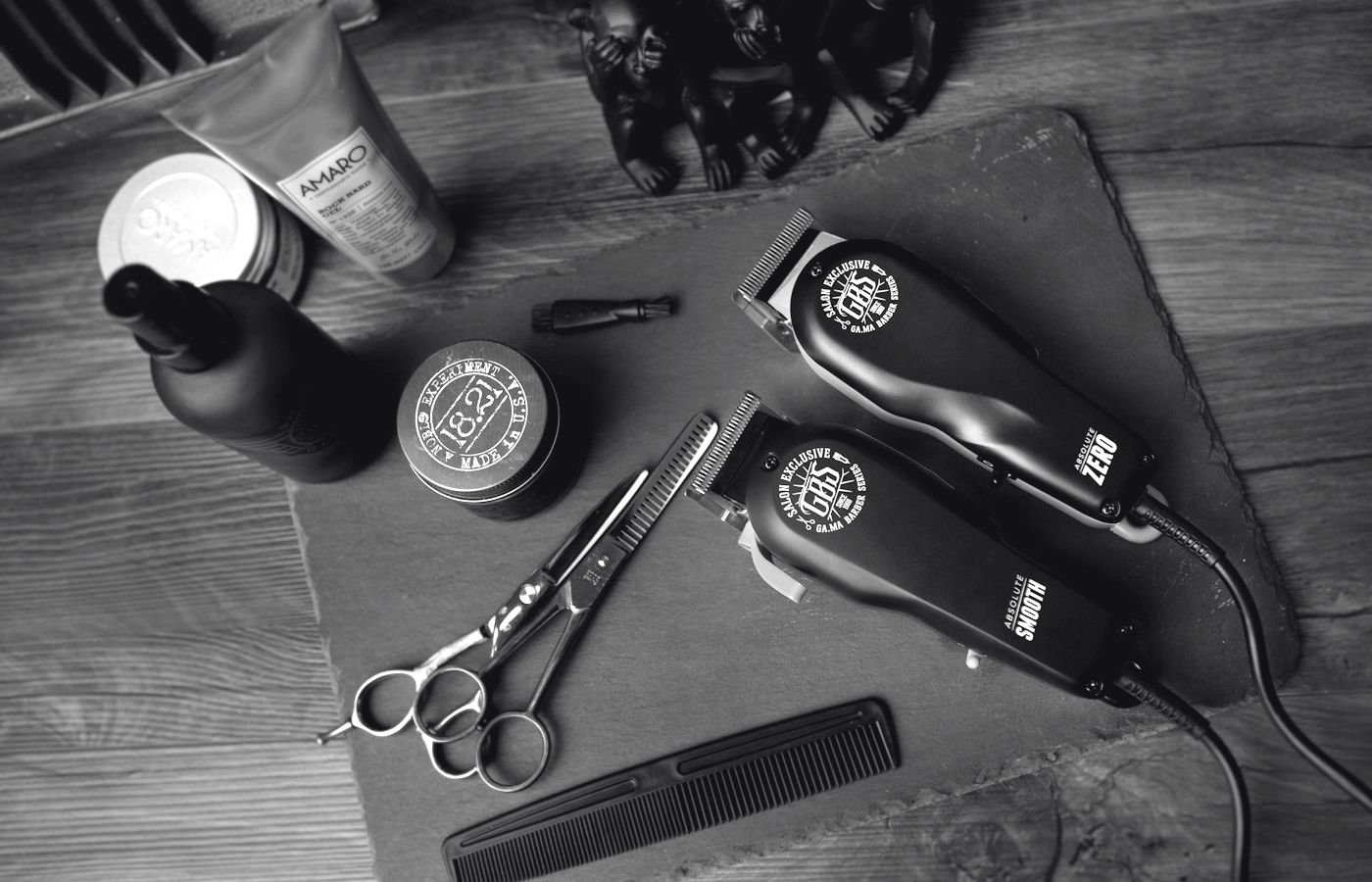 Gunting, clipper, sisir, dan pomade di meja kerja capster