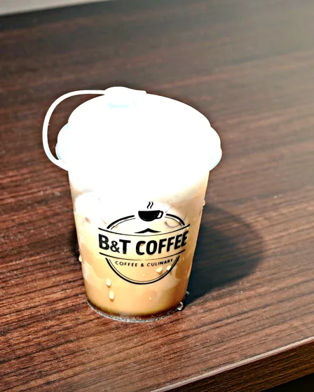 Segelas cafe latte dingin dalam gelas B and T Coffee